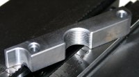n this example, a thread lock is completely machined, except for a 0.08 inch (2 mm) clamping surface. After the first operation, the part is turned over and the excess material is removed.